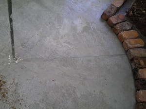 Wire attached to pole to measure inner and outer circle, so the bricks would end up on top of the thicker concrete